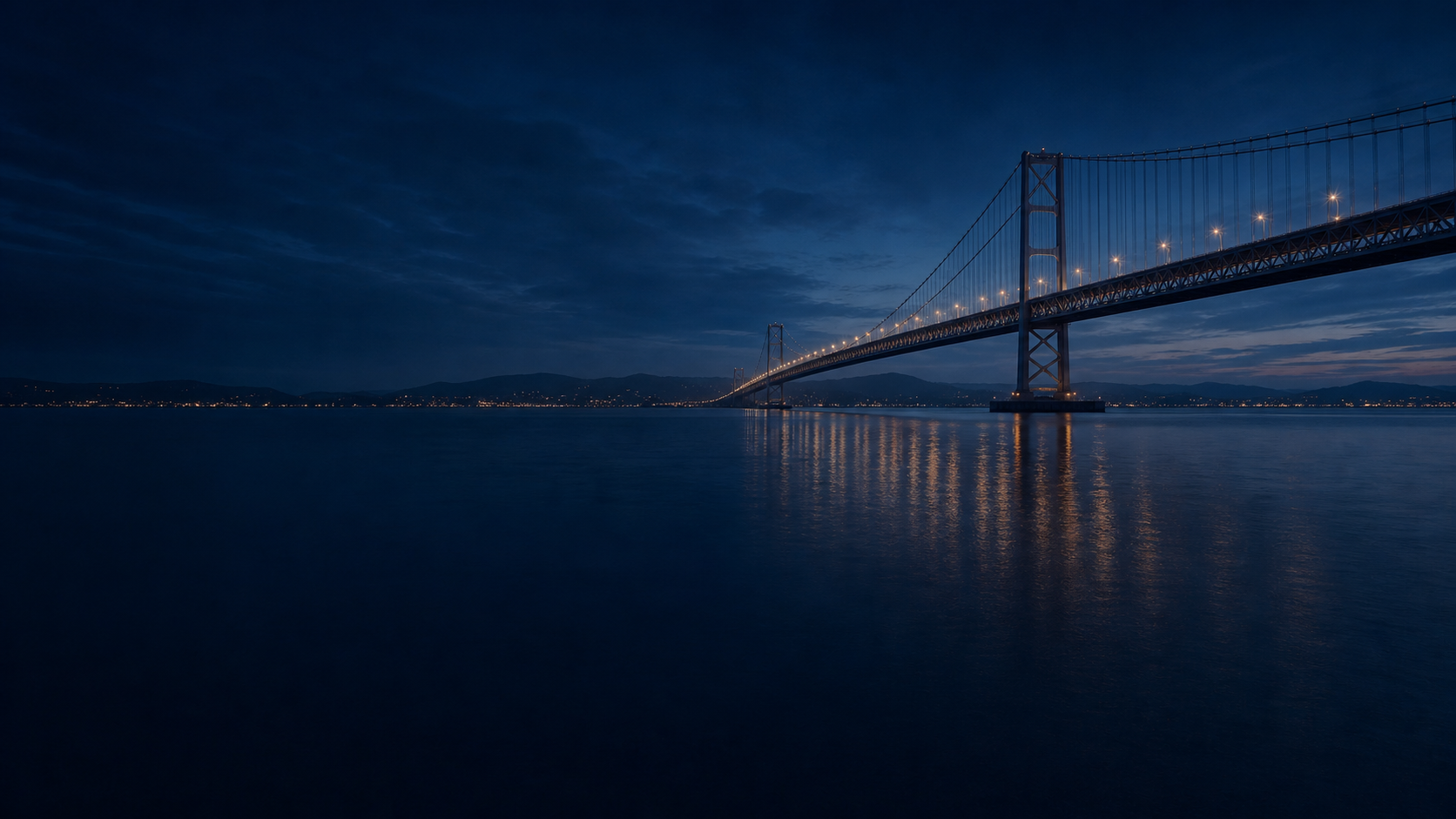 A lit bridge connecting two shores at night